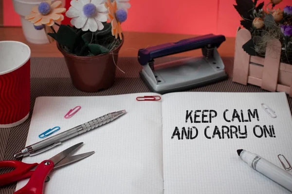 Word writing text Keep Calm And Carry On. Business concept for slogan calling for persistence face of challenge Scissors and writing equipments plus math book above textured backdrop.