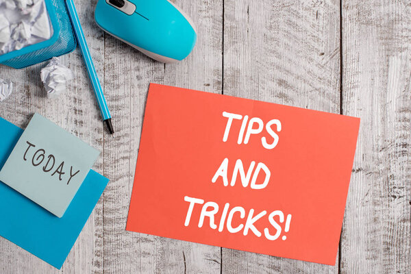Handwriting text writing Tips And Tricks. Concept meaning means piece advice maybe suggestion how improve Crumpled paper in bin and computer mouse with stationary on wooden backdrop.
