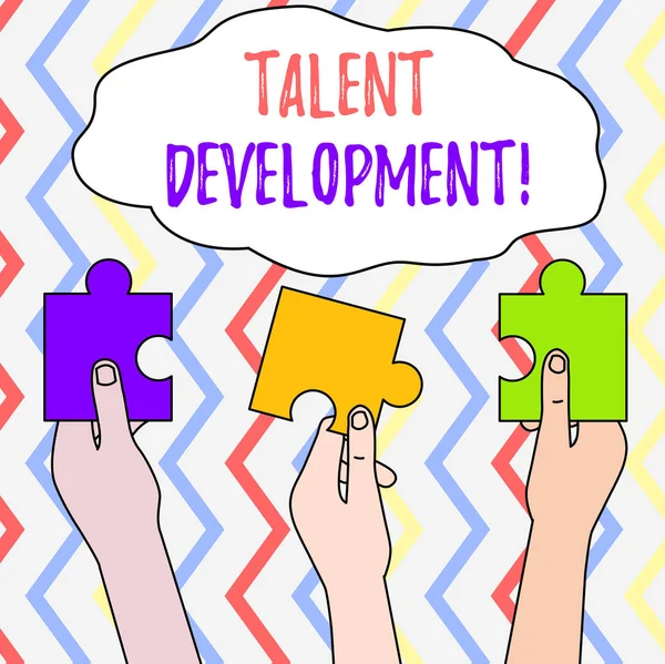 Handwriting text Talent Development. Concept meaning Building Skills Abilities Improving Potential Leader Three Colored Empty Jigsaw Puzzle Pieces Held in Different People Hands.