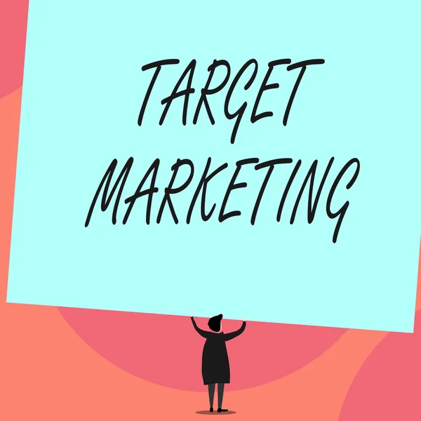 Word writing text Target Marketing. Business concept for Audience goal Chosen clients customers Advertising Back view standing short hair woman dress hands up holding blank rectangle.