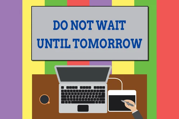 Text sign showing Do Not Wait Until Tomorrow. Conceptual photo needed to do it right away Urgent Better do now Upper view laptop wooden desk worker drawing tablet coffee cup office.