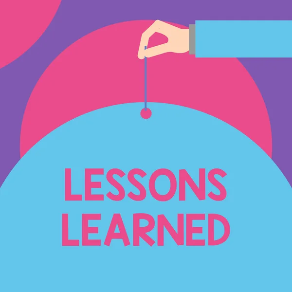 Handwriting text Lessons Learned. Concept meaning the knowledge or understanding gained by experience Male hand arm needle punching big half blank balloon geometrical background. — Stock Photo, Image