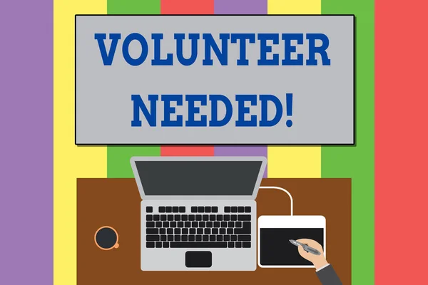 Text sign showing Volunteer Needed. Conceptual photo need work for organization without being paid Upper view laptop wooden desk worker drawing tablet coffee cup office. — Stockfoto
