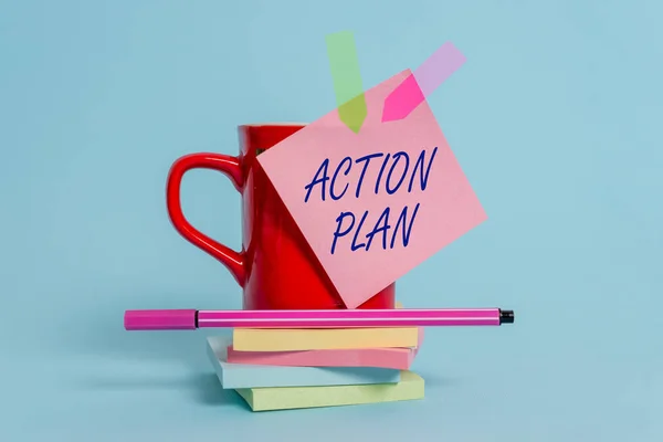 Word writing text action plan. Business-Konzept für vorgeschlagene Strategie oder Vorgehensweise für bestimmte Zeit Cup klebrige Note Pfeil Banner gestapelt Blöcke Stift liegen pastellfarbenen Hintergrund. — Stockfoto