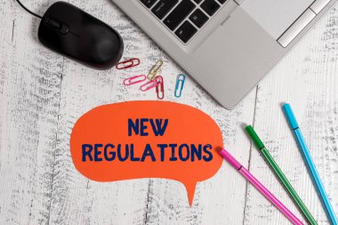 Yeni Düzenlemeleri gösteren metin işareti. Genellikle kurallar tarafından kullanılan etkinliği kontrol eden kavramsal fotoğraf Yönetmeliği. Metalik ince dizüstü konuşma kabarcık renkli klipler kalem fare ahşap vintage.