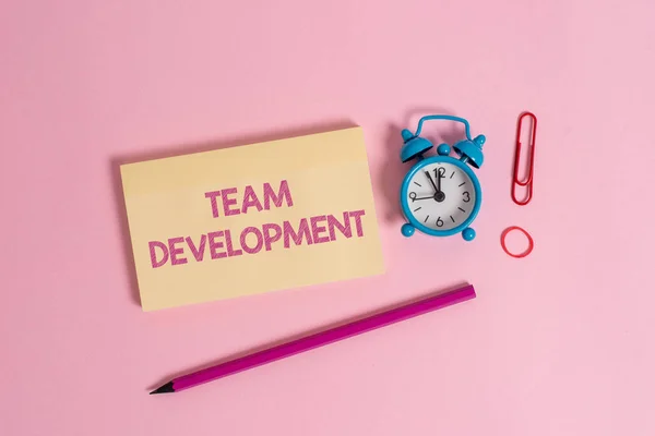 Word writing text Team Development. Business concept for learn why and how small groups change over time with graphs Colorful blank notepad marker retro alarm clock clip colored background. — Stock Photo, Image