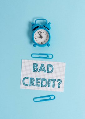 El yazısı metin yazma Bad Creditquestion. Bir borcu zamanında ve tam alarm saatinde uyandırmada bir gösteriş yapanın yetersizlik leri anlamına gelen kavram, kareli boş kağıt levha klipleri renkli arka plan.