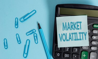 Piyasa Dalgalanmalarını gösteren not yazma. Temel menkul kıymet fiyatları dalgalanmaları İş fotoğraf Gösteriş durumu Elektronik hesap makinesi boş yapışkan not klipleri işaretrenkli arka plan.