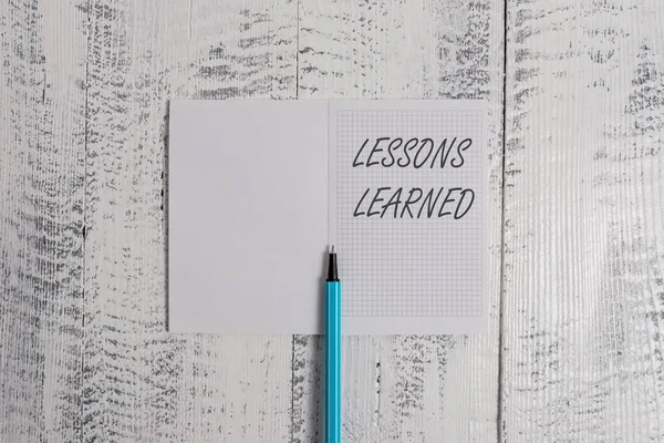 Conceptual hand writing showing Lessons Learned. Business photo showcasing information reflects positive and negative experiences Square notebook fine highlighter lying on wooden background. — Stock Photo, Image