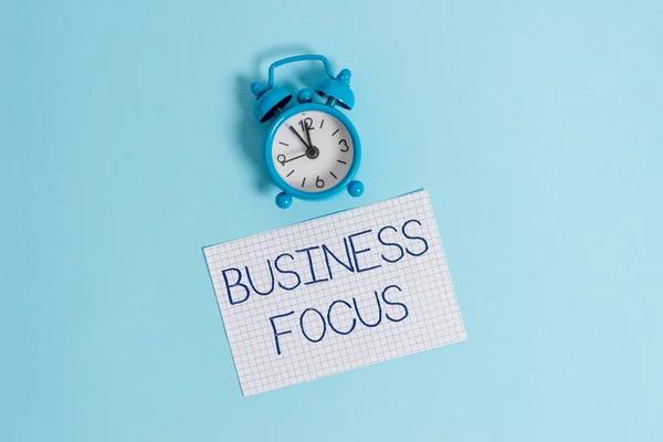 Word tekst schrijven Business focus. Bedrijfsconcept voor het bedienen van de behoeften van de klant volledige aandacht op Details Vintage wekker Wake up kwadraat leeg papier vel gekleurde achtergrond. — Stockfoto