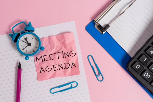 Konzeptionelle Handschrift, die die Tagesordnung des Treffens zeigt. Business-Foto-Text-Elemente, die die Teilnehmer hoffen, bei einem Treffen Papier Blatt Klemmbrett Bleistift Taschenrechner Uhr farbigen Hintergrund zu erreichen. — Stockfoto