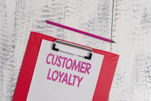 Handwriting text Customer Loyalty. Concept meaning result of consistently positive emotional experience Colored clipboard blank paper sheet pencil old wooden vintage background. — Stock Photo, Image