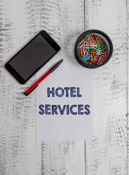 Conceptual hand writing showing Hotel Services. Business photo text Facilities Amenities of an accommodation and lodging house Smartphone paper sheet clips ballpoint wooden vintage background. — Stock Photo, Image