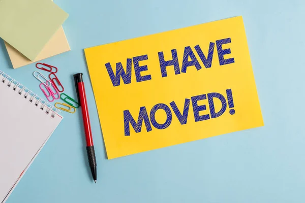 Writing note showing We Have Moved. Business photo showcasing To go from one residence or location to another Relocate Plain cardboard and writing equipment placed on pastel colour backdrop.