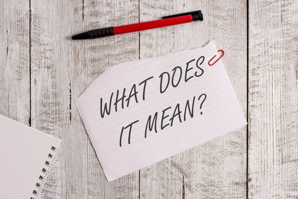 Kelime yazma metni Nedir Sorusu. Ahşap masanın üzerine yerleştirilen bir kalem ile belirsiz ifade Yırtık kağıt ve defter levha iletişim kurmak için amaçlanan iş konsepti.