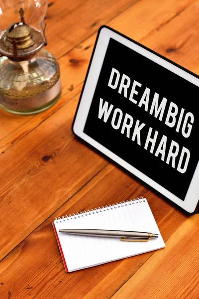 Handwriting text writing Dream Big Work Hard. Concept meaning Believe in yourself and follow the dreams and goals Writing equipments placed next to gadget plus a classic vintage lantern.