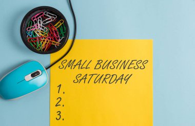 Small Business Cumartesi gösteren kavramsal el yazısı. İş fotoğraf metin Amerikan alışveriş tatil Cumartesi Notebook sırasında düzenlenen ve pastel fon üzerinde gadget'lar ile sabit.