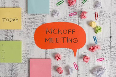 Kelime yazma metni Kickoff Meeting. Projede yer alan yasallıklar özel tartışma için İş konsepti Boş konuşma kabarcık kağıt topları klipler yapışkan notlar eski ahşap arka plan.