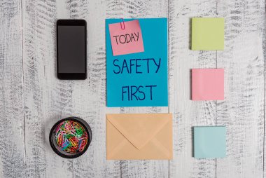 El yazısı metin Güvenlik İlk. Kavram anlamı en önemli şey güvenli Zarf mektup akıllı telefon not klipleri not defterleri ahşap vintage arka plan olmak olduğunu söylemek için kullanılır.