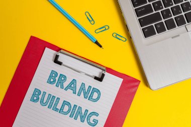 Kelime yazma metin Marka Oluşturma. Farkındalık oluşturma ve şirket Açık dizüstü bilgisayar panosu boş kağıt levha işaretçi klipleri renkli arka plan teşvik için İş kavramı.