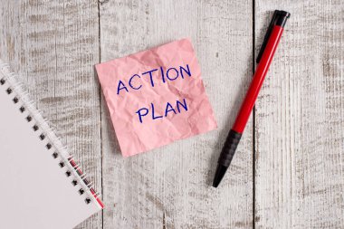 Eylem Planı'nı gösteren not yazma. Belirli bir süre için önerilen strateji veya eylemlerin ders vitrine İş fotoğraf Kırışıklık kağıt defter ve ahşap arka plan üzerine yerleştirilmiş sabit.