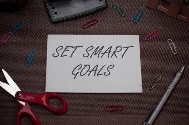 El yazısı metin yazma Set Akıllı Hedefler. Amaç makas ve yazma ekipmanları artı dokulu zemin üzerinde düz levha ayarında rehberlik etmek için kriterler veren kavram anlamı.