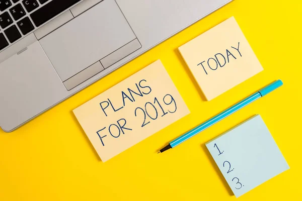 Conceptual hand writing showing Plans For 2019. Business photo text an intention or decision about what one is going to do Silver laptop square sticky notepads marker colored background. — Stock Photo, Image
