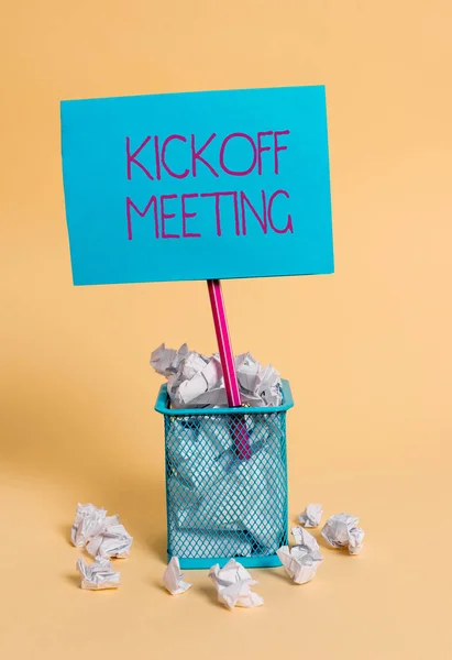 Palabra escribiendo texto Kickoff Meeting. Concepto de negocio para discusión especial sobre las legalidades involucradas en el proyecto de basura de papel arrugado y estacionario con papel de nota colocado en el bote de basura . — Foto de Stock