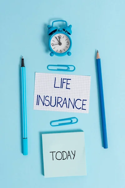 Writing note showing Life Insurance. Business photo showcasing Payment of death benefit or injury Burial or medical claim Alarm clock squared paper sheet notepad markers colored background.