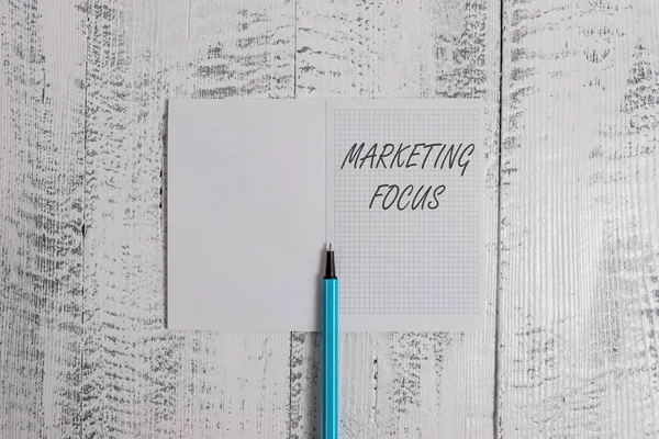 Escritura manual conceptual que muestra el enfoque de marketing. Foto de negocios mostrando la comprensión de sus clientes y sus necesidades utilizando estadísticas Cuaderno cuadrado resaltador fino acostado sobre fondo de madera . — Foto de Stock