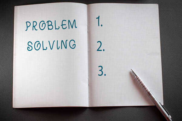 Word writing text Problem Solving. Business concept for process of finding solutions to difficult or complex issues Checkered math book and classic silver pen placed above textured work desk.