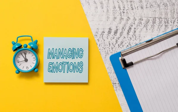 Escrita de mão conceitual mostrando Managing Emotions. Foto de negócios showcasing Controlando sentimentos em si mesmo Manter a compostura Bloco de notas colorido folha de papel despertador fundo de madeira . — Fotografia de Stock