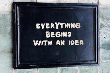Her şeyin bir fikirle başladığını gösteren bir not yazmak. Bir fikri gerçeğe dönüştürmek için attığınız adımları gösteren iş fotoğrafı.