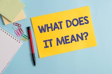 Ne Anlama Geldiğini gösteren not yazma sorusu. Belirsiz ifade Düz karton ve pastel renk zemin üzerine yerleştirilen yazma ekipmanları iletişim kurmak için amaçlanan İş fotoğraf vitrin.