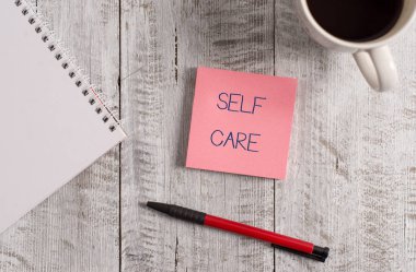 El yazısı metin Self Care. Kavram bir geliştirmek için harekete geçme pratiği anlamına gelir kendi sağlık Kırtasiye ahşap masa üzerinde siyah kahve bir fincan yanında yerleştirilir.