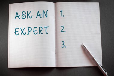 Kelime yazma metni Bir Uzman sor. Dokulu çalışma masasının üzerine yerleştirilen bir şey veya bilgili Damalı matematik kitabı ve klasik gümüş kalem hakkında becerisi olan birine danışmak için iş konsepti.