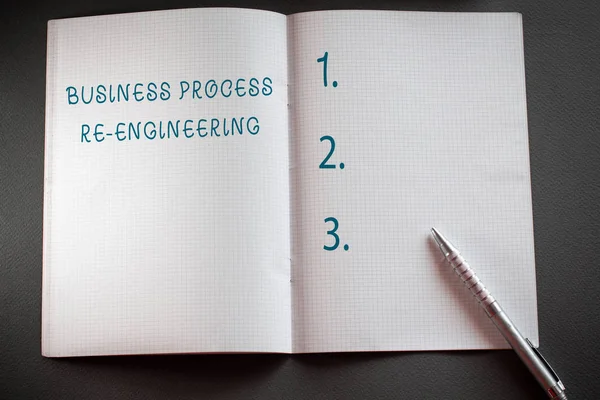 Написання тексту Бізнес-процес Re Engineering. Бізнес-концепція для аналізу та проектування робочих процесів Перевірена математична книга та класична срібна ручка, розміщена вище текстурованого робочого столу . — стокове фото
