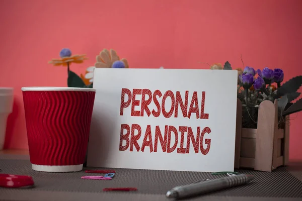 Writing note showing Personal Branding. Business photo showcasing Practice of People Marketing themselves Image as Brands Flowers and writing equipments sheet above textured backdrop.