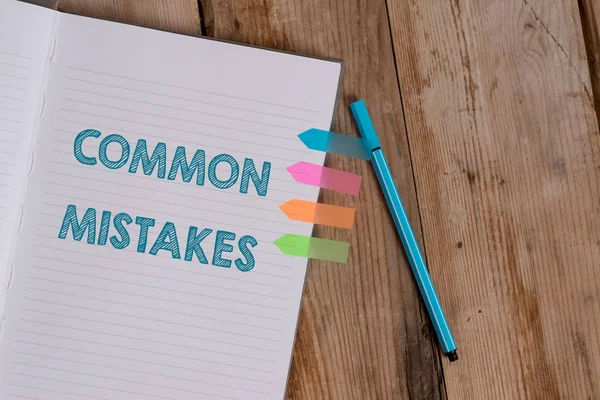 Conceptual hand writing showing Common Mistakes. Business photo text actions that are often used interchangeably with error Striped notebook colored arrow banners ballpoint wooden background. — Stock Photo, Image