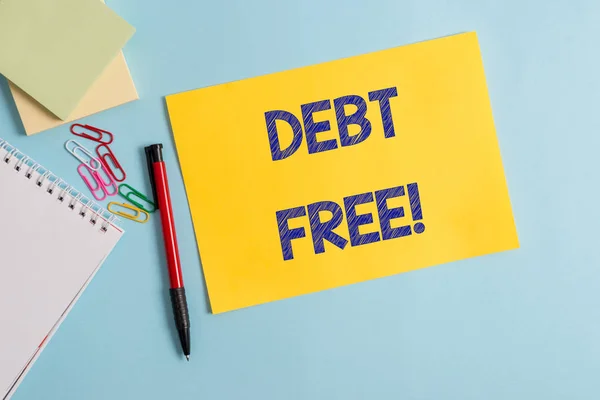 Writing note showing Debt Free. Business photo showcasing does not owning any money to any individual or companies Plain cardboard and writing equipment placed on pastel colour backdrop. — Stock Photo, Image