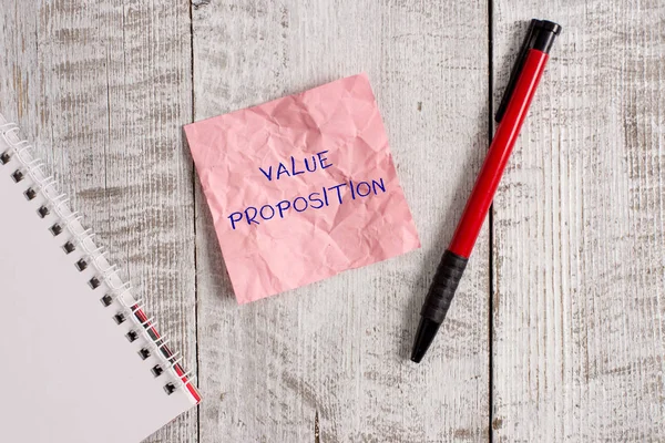 Writing note showing Value Proposition. Business photo showcasing feature intended to make a company or product attractive Wrinkle paper notebook and stationary placed on wooden background. — Stock Photo, Image