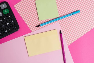 Renkli zemin üzerine yerleştirilmiş sabit ve noter kağıtları. Düz bir masaya not sayfaları ile ekipman yazma. Düz düzenleme sanatsal yolu fotoğraf bırakır