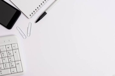 Reklam ve kısa mesaj için boş beyaz alana sahip iş konsepti. Pc klavye cep telefonu ve kalemi olan beyaz kopyalama alanı.