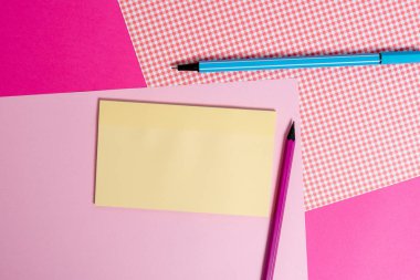 Renkli zemin üzerine yerleştirilmiş sabit ve noter kağıtları. Düz bir masaya not sayfaları ile ekipman yazma. Düz düzenleme sanatsal yolu fotoğraf bırakır