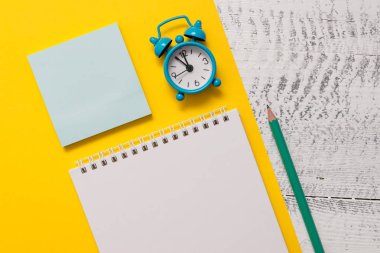 Closeup ön görünüm boş spiral not defteri kalem küçük çalar saat harf boyutu renkli kağıt levha yapışkan not defteri ahşap retro arka plan boş metin önemli olaylar ev ofis okulu