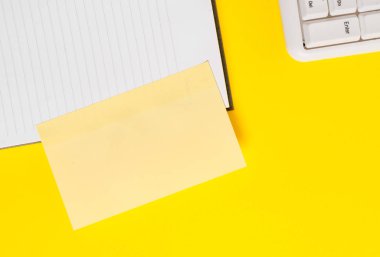 Sarı tabloüzerinde kopya alanı olan boş turuncu kağıt. Kısa mesajlar için boş kağıt. Masada boş kağıtlar olan iş konsepti.