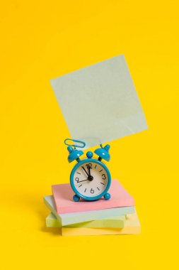Metal retro vintage çalar saat uyandırma boş kare yapışkan not çok renkli yığılmış not defterleri renkli arka plan Boş metin önemli olaylar ev ofis okul günlük