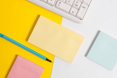 Turuncu arka plan masasının üzerinde kopya alanı ve pc klavyesi ile boş boş kağıdın üzerinde düz bir şekilde yer alır. Metin mesajı için kopya alanı renkli kağıt ile iş kavramı.