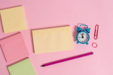 Dört çok renkli boş not defterleri mesaj lastik bant marker kalem küçük çalar saat uyandırma klip renkli arka plan boş metin önemli olaylar ev ofis okul