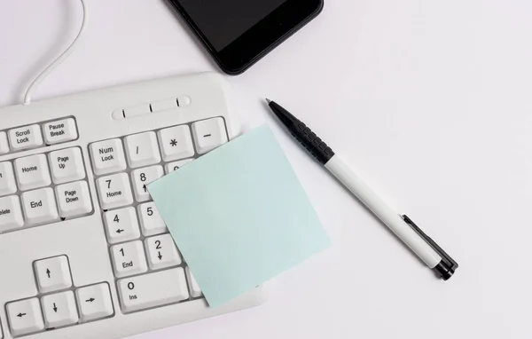Obchodní koncepce s poznámkami a počítačovou klávesnicí. Bílá PC klávesnice s prázdným papírovým papírem nad bílým pozadím. Prázdný papírový prostor pro textovou zprávu. — Stock fotografie